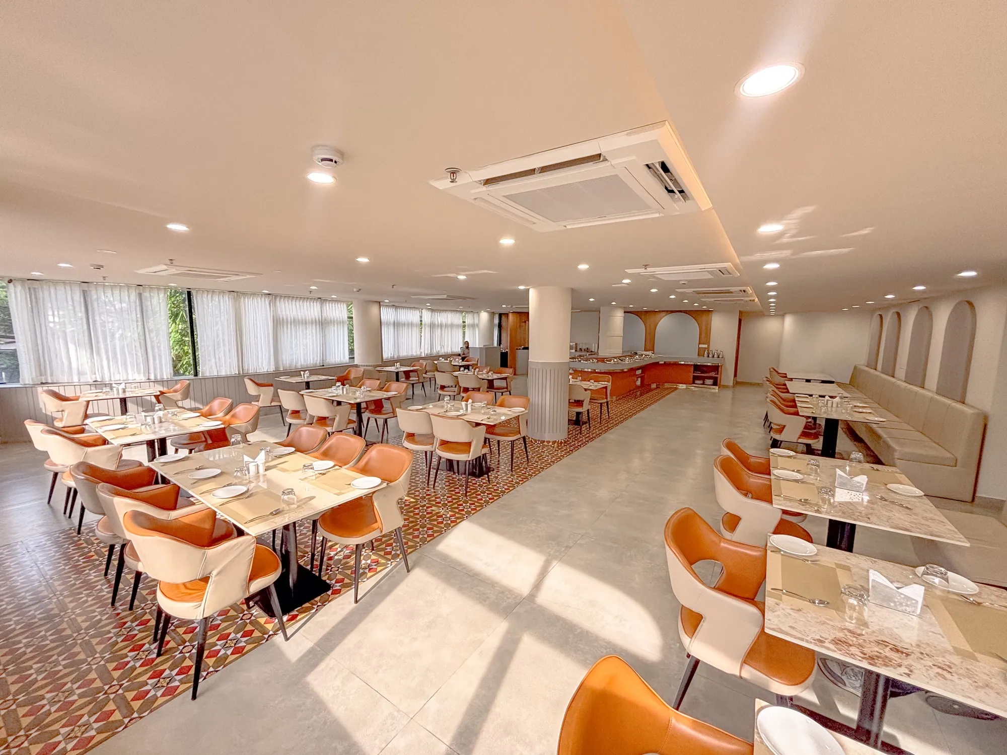 Restaurant dining hall at Hotel Explora Calicut with orange seating and buffet